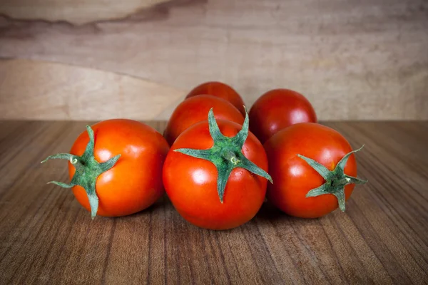 Close-up tomates maduros frescos sobre fundo de madeira — Fotografia de Stock