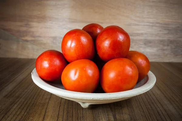 Close-up tomates maduros frescos sobre fundo de madeira — Fotografia de Stock