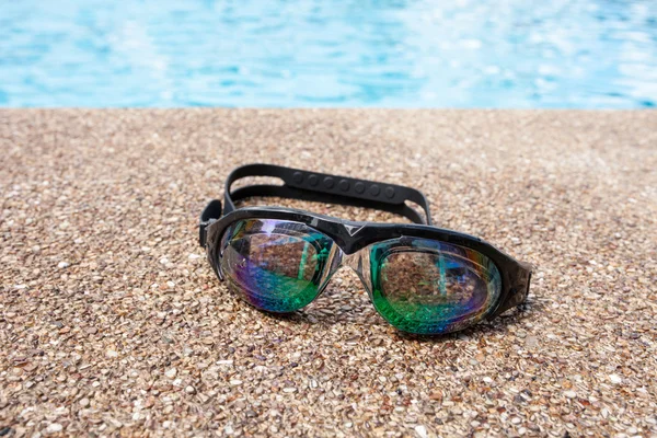 Gläser zum Schwimmen auf einem Zementboden mit kleinem Stein in der Nähe von swi — Stockfoto