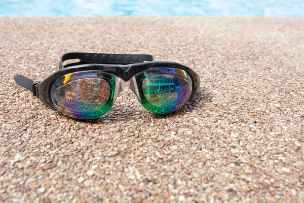 Gläser zum Schwimmen auf einem Zementboden mit kleinem Stein in der Nähe von swi — Stockfoto