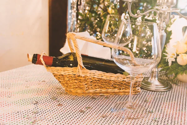 Bir şişe şarap ahşap sepet ve bardak masada — Stok fotoğraf