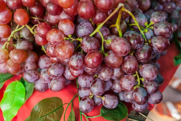 Спелый красный виноград с листьями на столе — стоковое фото