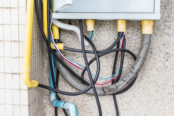 Zu viele Kabelstecker in einer Buchse an der Ziegelwand. Gefahr des Einsatzes — Stockfoto