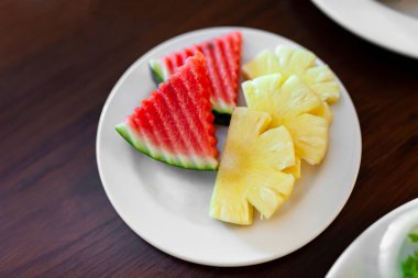 Taze karpuz ve ananas kaydırağı beyaz tabakta..