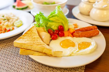 Tam Amerikan Kahvaltısı, koyu renk, üst manzara, afiş. Kızarmış yumurta, kızarmış domuz pastırması, kızarmış et ve kızarmış ekmek.