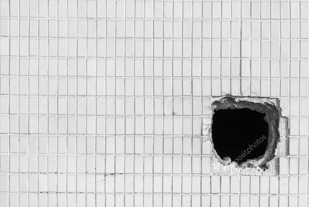 Hole on the old white wall