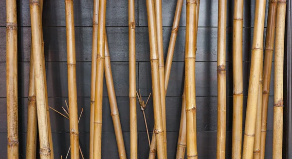 Yellow bamboo stängsel bakgrund på svart trä — Stockfoto