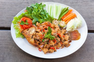 ahşap arka plan üzerinde beyaz tabak içinde şekil balık