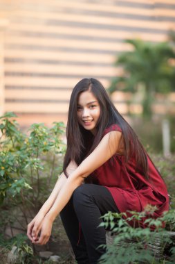 Doğa Park kırmızı takım elbise ile güzel kız gülümsüyor