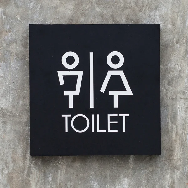 Bathroom sign on a cement wall — Stock Photo, Image