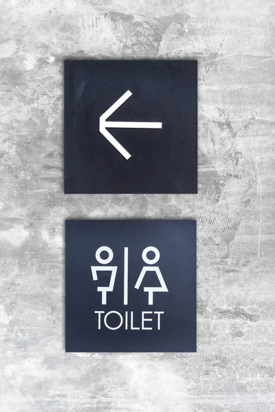 Toilettes unisexes ou signe fléché sur un mur en béton — Photo