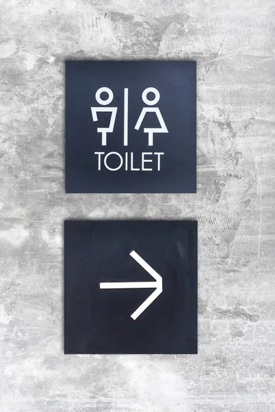 Unisex restroom or Toilet and arrow sign on  concrete wall style — Stock Photo, Image