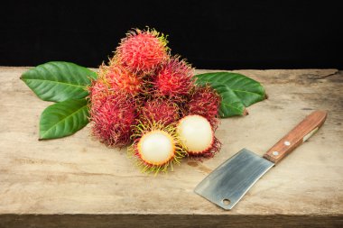 taze meyve rambutan Tayland ve bir knif ahşap arka plan üzerinde