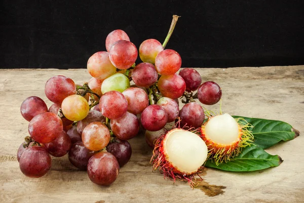 新鮮なフルーツの赤ブドウとウッドの背景にランブータン — ストック写真