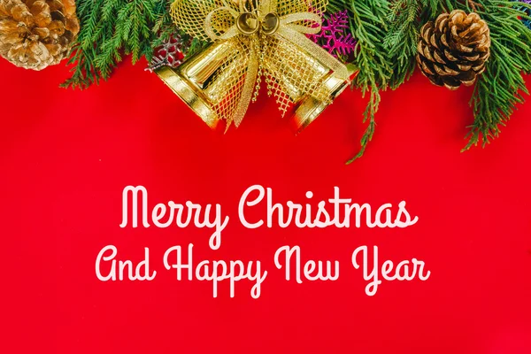 Abete di Natale con coni e campana d'oro su un backgroun rosso — Foto Stock