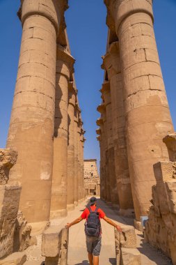 Mısır 'daki Lüksör Tapınağı' nda Mısır çizimleri olan değerli sütunların yanında genç bir turist.