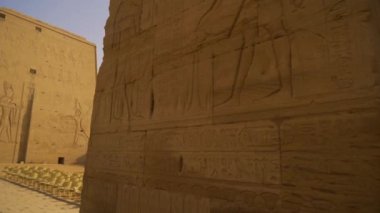 Genç bir turist Edfu Tapınağına doğru yürüyor. Mısır. Aswan yakınlarındaki Edfu şehrinde bulunan Nil Nehri, Horus 'a adanmış Greko-Romen inşaatı.