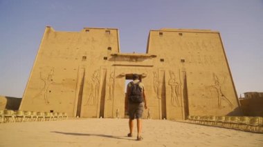 Genç bir turist Edfu Tapınağına doğru yürüyor. Mısır. Aswan yakınlarındaki Edfu şehrinde bulunan Nil Nehri, Horus 'a adanmış Greko-Romen inşaatı.