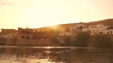 Yanıt kasabası yakınlarındaki bir tekneden denize açılan bir Nubian köyünün güzel bir gün batımı. Mısırca