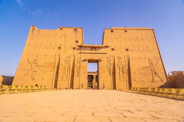 Facade with drawing of pharaohs of the Temple of Edfu in the city of Edfu, Egypt. On the bank of the Nile river, geco-Roman construction, temple dedicated to Huros clipart