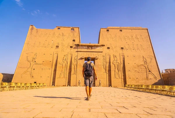 Genç bir turist Edfu, Mısır 'daki Edfu Tapınağı' na giriyor. Nil nehrinin kıyısında, kertenkele-Roma inşaatı, Huros 'a adanmış tapınak.
