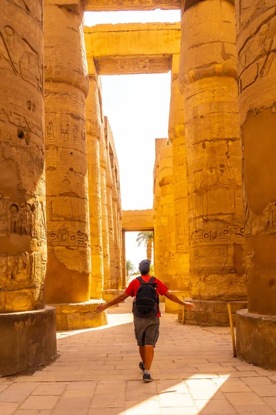 若い男がカルナック神殿 アムンの偉大な聖域の象形文字列の間を散歩 エジプト — ストック写真