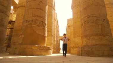 Karnak tapınağını ziyaret eden genç bir kadın ve onun güzel hiyeroglif sütunları, Amun 'un büyük mabedi. Mısır