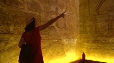 Genç bir turist, Nasser Gölü 'nün yanındaki Güney Mısır' daki Abu Simbel Tapınağı 'nın içindeki hiyerogliflere bakıyor. Firavun 2. Ramss Tapınağı, 4k video