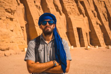 Mısır 'ın güneyindeki Abu Simbel yakınlarındaki Mısır Nefertari Tapınağı' nı ziyaret eden mavi türbanlı genç bir adam Nubia 'da Nasser Gölü' nün yanında. Firavun 2. Ramses Tapınağı, seyahat yaşam tarzı.