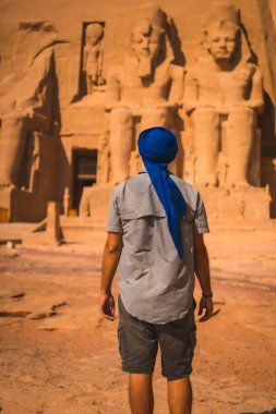 Mavi sarıklı genç bir turist Güney Mısır 'daki Abu Simbel Tapınağı' na bakıyor. Nubia 'da Nasser Gölü' nün yanında. Firavun 2. Ramses Tapınağı, seyahat yaşam tarzı.
