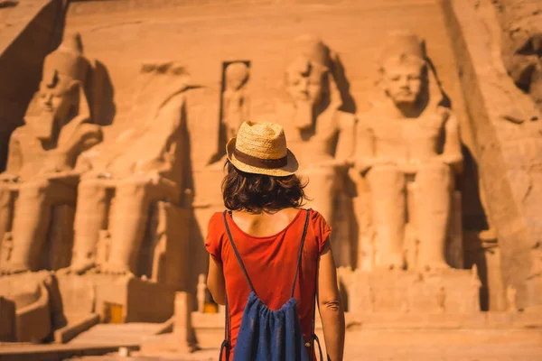 一名身穿红色衣服头戴草帽的年轻游客走向埃及南部努比亚靠近纳赛尔湖的阿布辛贝尔神庙 法老的庙宇拉姆西斯二世 旅行生活方式 — 图库照片