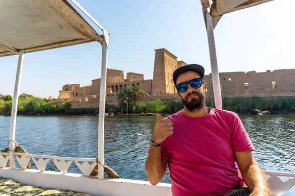 A young man on the boat that takes you to the Temple of Philae with its beautiful columns, a Greco-Roman construction on the River Nile, a temple dedicated to Isis, goddess of love. Aswan. Egyptian