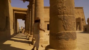 Genç bir kadın, aşk tanrıçası Isis 'e adanmış bir tapınak olan Nil Nehri' nden görülen güzel bir Greko-Romen yapısını ziyaret ediyor. Aswan. Mısırca