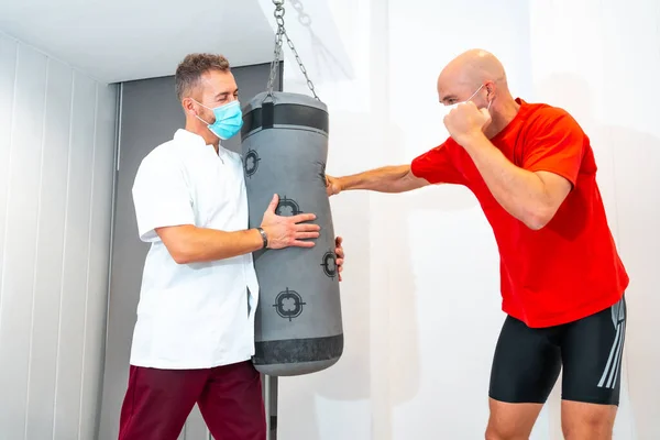 Fisioterapeuta Con Máscara Paciente Haciendo Algunos Ejercicios Saco Boxeo Fisioterapia —  Fotos de Stock