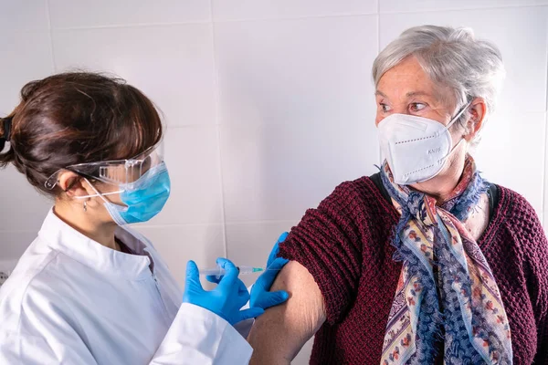 Vrouwelijke Arts Die Het Coronavirusvaccin Een Oudere Dame Aanbrengt Antilichamen — Stockfoto