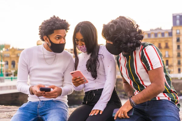 ライフスタイル 3人の黒人ラテン系の友人が路上で電話を楽しんでいます コロナウイルスのパンデミックにおける友情 Covid 社会的距離社会的責任新しい普通 — ストック写真