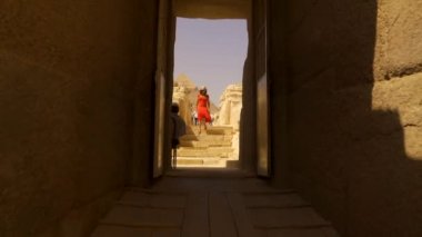 Kırmızı elbiseli genç bir kadın Ginza Piramitleri 'nin yanındaki Büyük Ginza Sfenksini ziyaret ediyor. Kahire, Mısır