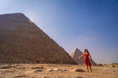 Cheops Piramidi 'nde kırmızı elbiseli genç bir kız. En büyük piramit. Giza Piramitleri dünyanın en eski cenaze anıtı. Mısır 'ın Kahire şehrinde