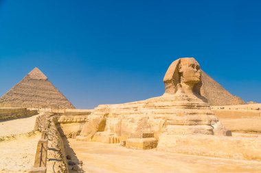 Giza 'nın Büyük Sfenksi ve arka planda bir yaz öğleden sonra Giza Piramitleri, dünyanın en eski Cenaze Anıtı. Mısır 'ın Kahire şehrinde