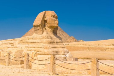 Giza 'nın Büyük Sfenksi ve arka planda bir yaz öğleden sonra Giza Piramitleri, dünyanın en eski Cenaze Anıtı. Mısır 'ın Kahire şehrinde