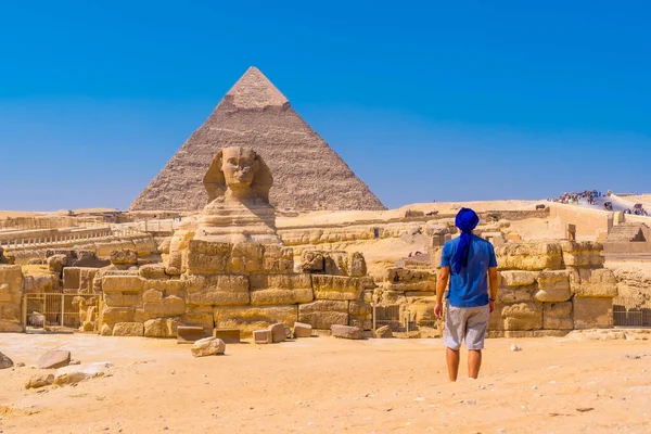 一个年轻人走向吉萨的狮身人面像 背景是哈夫尔金字塔 吉萨金字塔 埃及开罗 — 图库照片