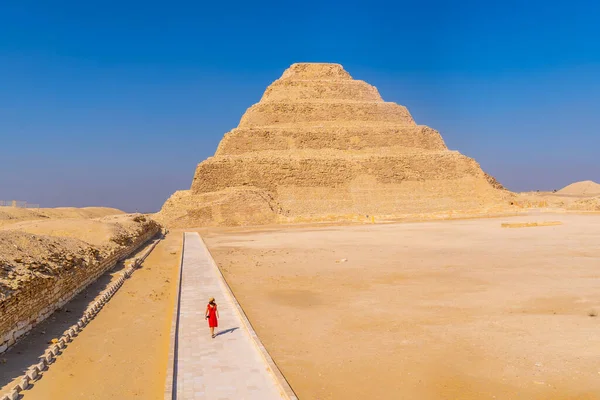赤のドレスを着た少女がサッカラのドシエの急なピラミッドの中を歩いている エジプトだ メンフィスで最も重要なネクロポリス 世界初のピラミッド — ストック写真