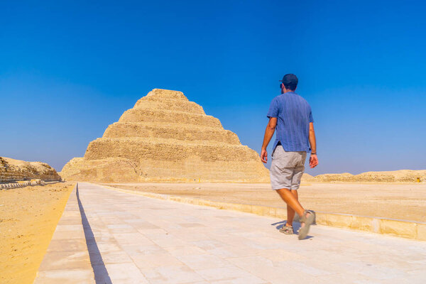 A young man walking in the Stepped Pyramid of Djoser, Saqqara. Egypt. The most important necropolis in Memphis. The first pyramid in the world