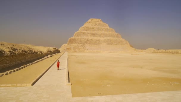 一位年轻妇女参观了Djoser的阶梯金字塔 从上面看 Saqqara 孟菲斯最重要的墓地世界上第一个金字塔 — 图库视频影像