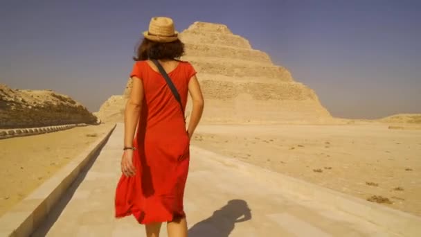 一名身穿红色礼服的年轻游客在萨卡拉州朱瑟的台阶金字塔 孟菲斯最重要的墓地世界上第一个金字塔 — 图库视频影像