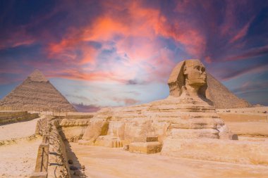 Giza 'nın Büyük Sfenksi ve arka planda Giza Piramitleri, günbatımında, dünyanın en eski cenaze anıtı. Mısır 'ın Kahire şehrinde