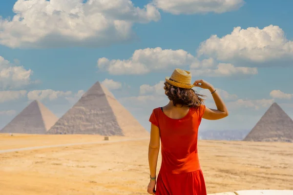 一位身穿红衣服的年轻游客 望着吉萨金字塔 世界上最古老的殡仪馆 在埃及开罗市 — 图库照片