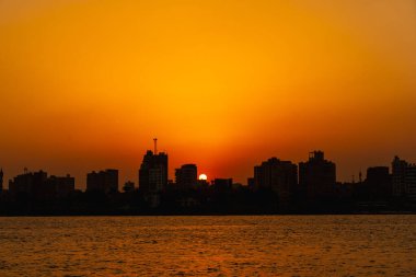 Günbatımı Kahire şehrinin ufuk çizgisinde, güneş arka plandaki Kahire şehrinin binalarının üzerine batar. Afrika