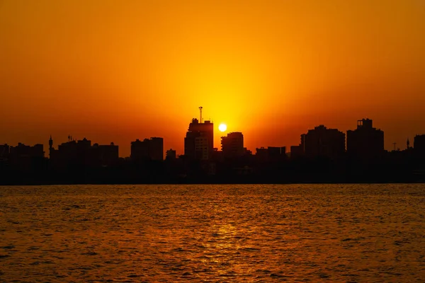 Pomarańczowy Zachód Słońca Nad Nilu Słońce Ukrywa Się Budynkach Miasta — Zdjęcie stockowe