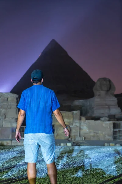 一位年轻的欧洲游客在吉萨美丽的金字塔和狮身人面像的光天化日之下观看 开罗市的夜晚非洲 — 图库照片